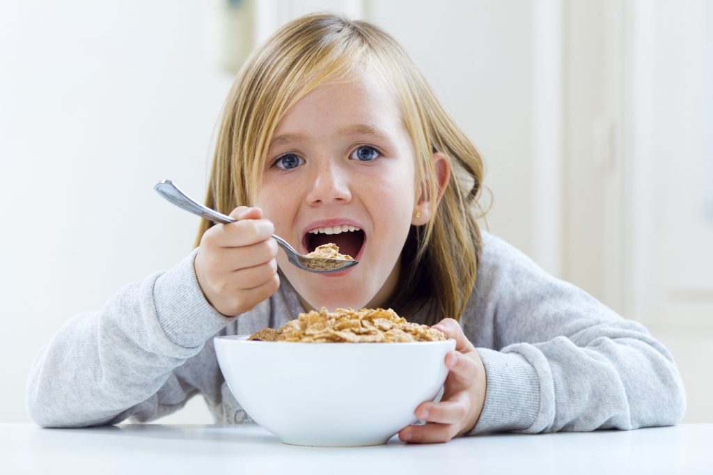 Beautiful child having breakfast at home.