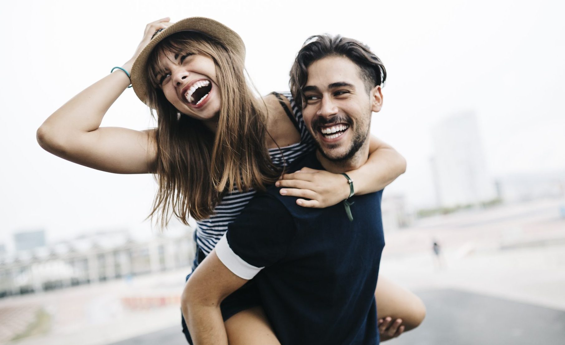 Spain, Barcelona, Young Man Giving His Girlfriend A Piggyback Ride