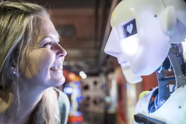 Happy Technician Looking At Human Robot With Heart Shape In Eye