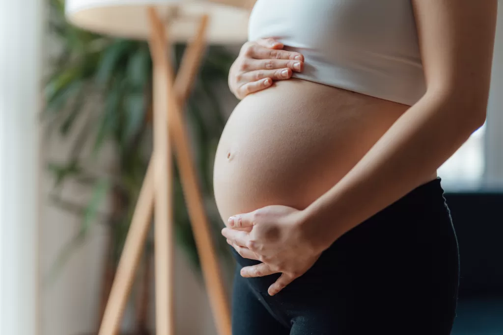 Midsection Of Pregnant Woman Holding Her Belly