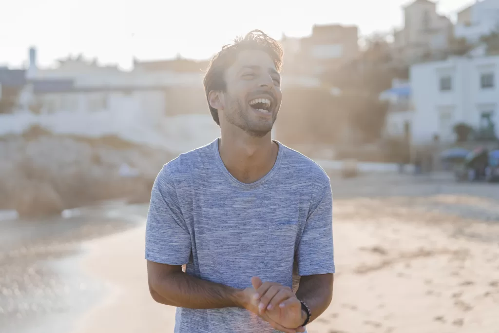 Laughing Young Man On The Beach At Sunset