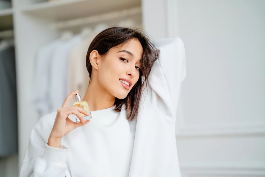 Toothy Smiling Woman Spraying And Testing Perfume Oil Water On Her Neck