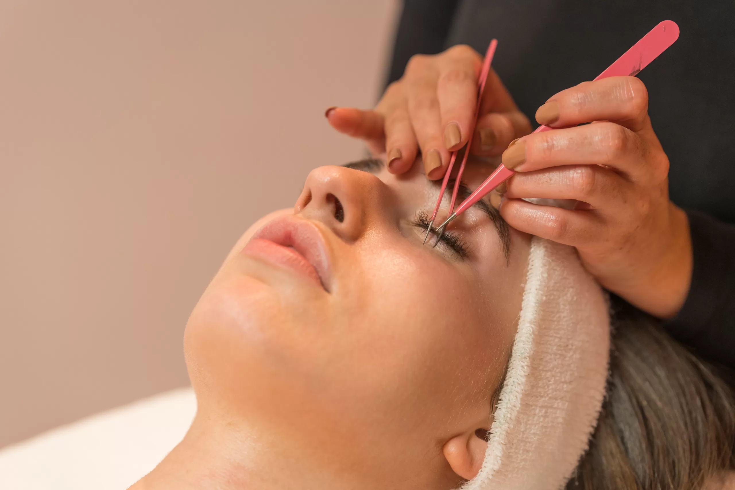 Close Up View Of A Woman During An Eyelash Extension Procedure In A Beauty Salon.