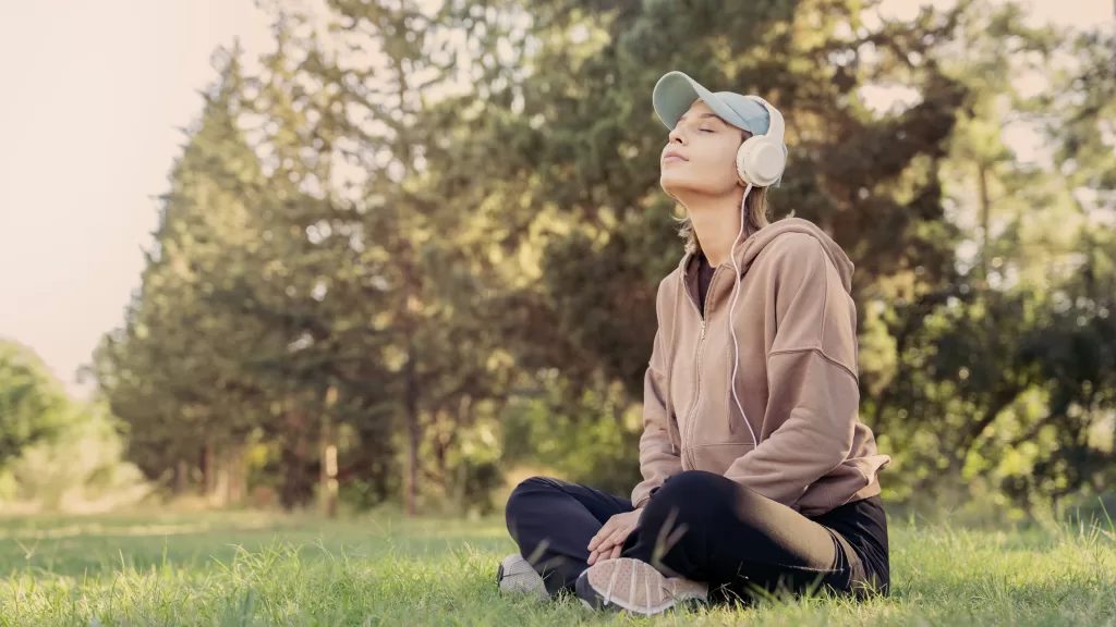 Woman Listening To Music With Headphones In The Nature